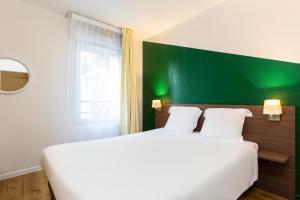 Postel nebo postele na pokoji v ubytování Aparthotel Adagio Access Carrières Sous Poissy