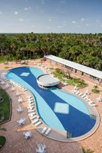 una vista aérea de una piscina con sillas y un edificio en Hotel - Gran Lençóis Flat en Barreirinhas