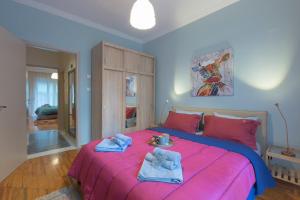 um quarto com uma cama rosa e toalhas em Thess1home Apartments em Tessalónica
