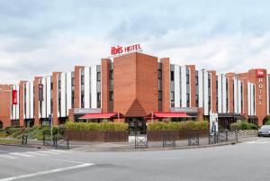 a building with a sign on top of it at Ibis Évry-Courcouronnes in Evry-Courcouronnes