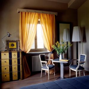 une chambre avec une table, des chaises et une fenêtre dans l'établissement Albergo l'Ostelliere - Villa Sparina Resort, à Gavi