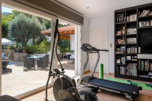 une salle de sport avec un tapis roulant et une étagère à livres dans l'établissement Villa Blanca Santa Eulalia, à Santa Eulària des Riu