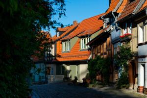 a cobblestone street with houses with orange roofs at Zum fröhlichen Tagelöhner in Quedlinburg