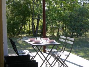 un tavolo con ciotole e sedie su un patio di 3Houses N°1 a Lagorce