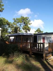 a house with a porch and a deck at Camping la Palmyre in Les Mathes