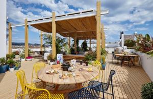 a wooden table and chairs on a patio at Gran Hotel Flamingo-Adults Only older 18 years old in Lloret de Mar