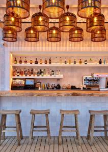a bar with wooden stools and chandeliers at Gran Hotel Flamingo-Adults Only older 18 years old in Lloret de Mar