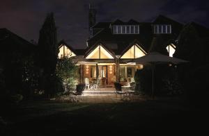 a house lit up at night with an umbrella at Fredrick's Hotel Restaurant Spa in Maidenhead