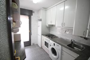 a kitchen with a sink and a washing machine at La Casita del Pirineo in Villanúa +12 photos