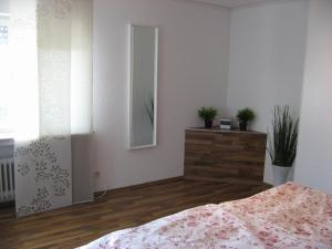 Schlafzimmer mit einem Bett, einer Kommode und einem Spiegel in der Unterkunft Willkommen zuhause! Welcome home! in Koblenz