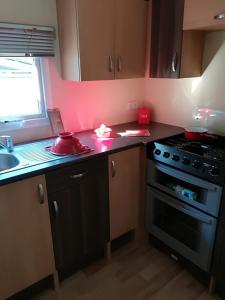 a kitchen with a black stove and a sink at Camping la Palmyre in Les Mathes