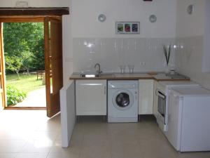 a kitchen with a washing machine and a sink at Las Navedas in Santibáñez de Villacarriedo