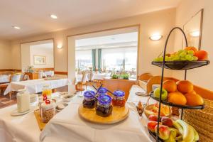 a table with food and fruit on it in a restaurant at Appartementhaus EifelAdventures in Berlingen