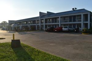 a large building with cars parked in a parking lot at Motel 6 Lake Charles, LA in Lake Charles