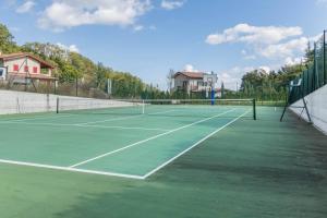 a green tennis court with a net on it at ALTIDO Superb Villa with Tennis Court, Garden and BBQ area in Valle