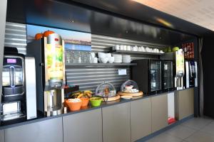 a coffee shop with a counter with food and drinks at Appart-Hôtel Mer & Golf City Bordeaux - Bruges in Bruges