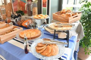 a buffet of bread and pies on a blue table at Appart-Hôtel Mer & Golf City Bordeaux - Bruges in Bruges