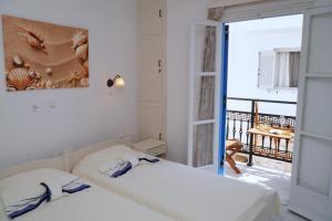 a bedroom with two beds and a balcony at Diogenis Studios in Naxos Chora