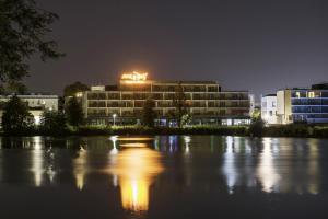 a building with lights on top of it at night at Appart-Hôtel Mer & Golf City Bordeaux - Bruges in Bruges