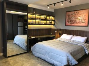 a bedroom with two beds and a desk and a mirror at Apartamento super bem decorado em frente ao shopping in Curitiba