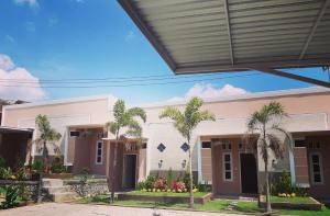 a building with palm trees in front of it at Bis homestay in Sumbawa Besar