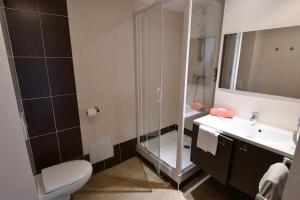 a bathroom with a shower and a toilet and a sink at Appart-Hôtel Mer & Golf City Bordeaux - Bruges in Bruges
