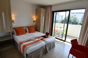a hotel room with a bed with a laptop on it at Appart-Hôtel Mer & Golf City Bordeaux - Bruges in Bruges
