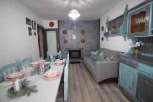 een keuken en een woonkamer met een tafel en een bank bij La Casita del Pirineo in Villanúa