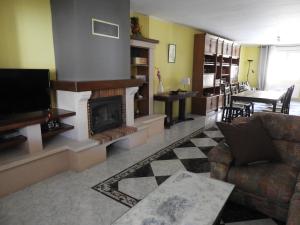 ein Wohnzimmer mit einem Kamin und einem Sofa in der Unterkunft Casa 5 Habitaciones Valseca - Segovia in Valseca