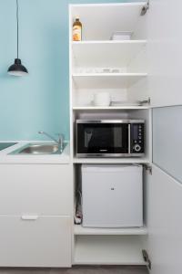 Il comprend une cuisine équipée d'un four micro-ondes et d'un réfrigérateur blanc. dans l'établissement Studio Apartments nahe Messe, à Nuremberg