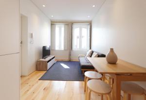 un soggiorno con tavolo e divano di HM - Charming Pinheiro Duplex Apartment a Porto