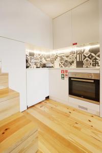 a kitchen with white cabinets and a stainless steel oven at HM - Charming Pinheiro Duplex Apartment in Porto