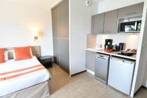a small room with a bed and a kitchen at Appart-Hôtel Mer & Golf City Bordeaux - Bruges in Bruges