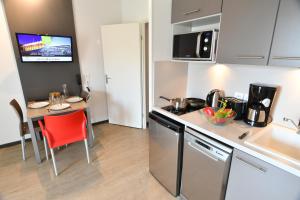 a small kitchen with a table and a counter top at Appart-Hôtel Mer & Golf City Bordeaux - Bruges in Bruges