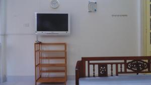 un soggiorno con una TV a schermo piatto su una parete di Homestay Nam Dong a Hanoi