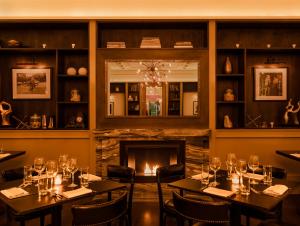 a room with a fire place and a table with wine glasses on it at HGU New York in New York