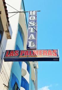 una señal de las palmas en el lateral de un edificio en Hostal Las Palmeras en Jaén