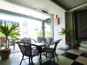a patio with a table and chairs on a checkered floor at Clover Hotel Port Dickson in Port Dickson