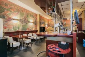 un restaurante con bar, mesas y sillas en Hotel Montagna Delmondo, en Valkenburg