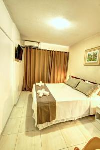 a bedroom with a bed with two towels on it at Hotel Vela Azul in Balneário Camboriú