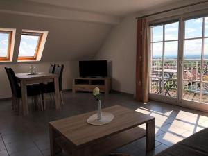 ein Wohnzimmer mit einem TV und einem Tisch mit einer Vase in der Unterkunft Hotel & Restaurant Weinberg in Baden-Baden