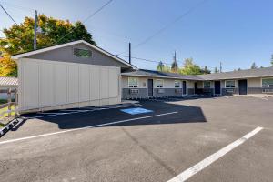 a building with a white garage in a parking lot at North Idaho Inn in Coeur d'Alene