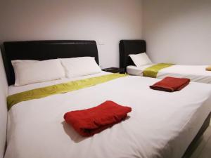 ポートディクソンにあるクローバー ホテル ポート ディクソンのベッドルーム1室(赤いタオル付きのベッド2台付)
