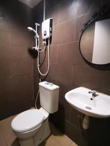 a bathroom with a toilet and a sink at Clover Hotel Port Dickson in Port Dickson