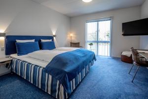 a bedroom with a large bed and a large window at Molskroen Strandhotel in Ebeltoft