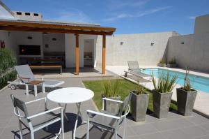 un patio con mesa, sillas y piscina en Corzuelas Aparts - Mina Clavero en Mina Clavero