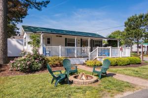 a house with two chairs and a fire pit at Bethpage One-Bedroom Cottage 1 in Urbanna