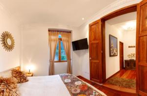 Un dormitorio con una cama grande y una ventana en Vista del Angel Hotel Boutique, en Quito