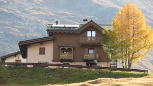 Ein Haus auf einem Hügel mit Bergen im Hintergrund in der Unterkunft Al Dos in Livigno