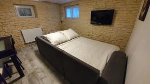 een bed in een kamer met een bakstenen muur bij "LE TRAMWAY" Appartement 150m gare des Aubrais in Fleury-les-Aubrais